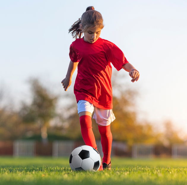 Girl practicing with soccer ball